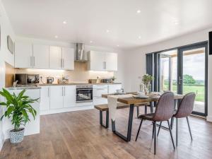 a kitchen and dining room with a table and chairs at Oak Tree Lodge - Uk38383 in Lyonshall