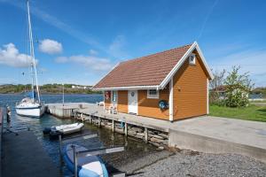 een klein huis op een dok met boten op het water bij RoaldsPiren Stavanger in Stavanger