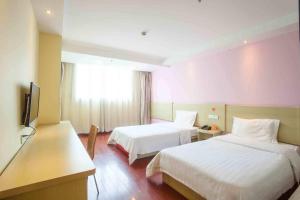 a hotel room with two beds and a television at 7Days Inn Chengdu North Train Station Wukuaishi in Chengdu