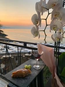 una mesa con una copa de vino y algo de comida y flores en Il Tramonto en Široka