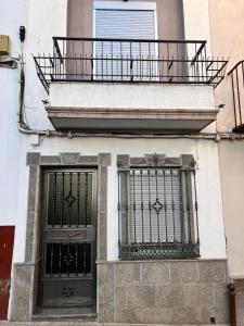 - un bâtiment avec deux portes et un balcon dans l'établissement Las Parras House - Casa en Torredelcampo, à Torre del Campo