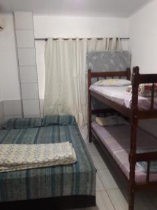 a room with two bunk beds and a window at Apartamentos C. Santos in Penha