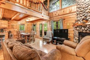 una sala de estar con sofá y TV en una cabaña en Bear Pleasures, en Gatlinburg