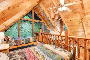 Dormitorio en cabaña de madera con 2 camas y ventilador de techo en Bear Pleasures, en Gatlinburg