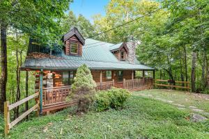 a cabin in the woods with a green roof at Bear Pleasures in Gatlinburg