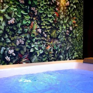 eine mit Pflanzen bedeckte Wand neben einem Pool in der Unterkunft DESTASU' Bed and Wellness in Castel del Monte