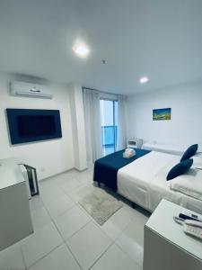 Habitación de hotel con cama y TV en Hotel Real en Cabo Frío