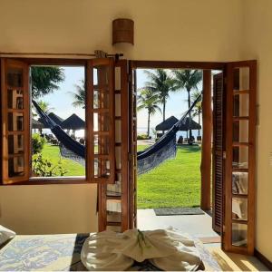 uma porta aberta com vista para uma rede de descanso a partir de um quarto em Pousada Ponta do Muta em Barra Grande