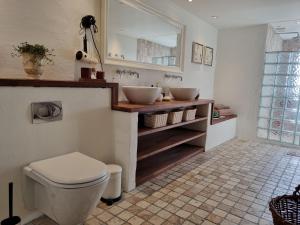 a bathroom with two sinks and a toilet at Birkelund BnB in Otterup