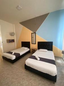 - deux lits dans une chambre d'hôtel avec deux couvre-lits dans l'établissement HOTEL CALLE REAL SUITE, à Medellín