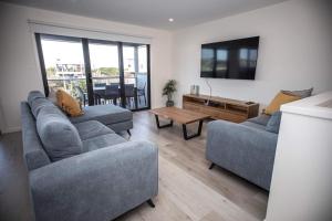 uma sala de estar com dois sofás e uma televisão em Loch Ard Place em Peterborough