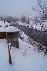 a bridge covered in snow next to a river at Maison d'Imelda in Petit-Saguenay