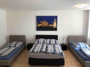 a bedroom with two beds and a painting on the wall at Potsdamer Platz-Top Spot Studio 1 in Berlin