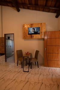 ein Wohnzimmer mit einem Tisch und einem Fernseher an der Wand in der Unterkunft Pousada Pitauá in Socorro + 37 Fotos