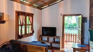 a living room with a couch and a tv at Wood Cabin - Cabana Maderas in Balgue