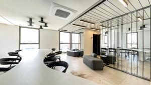 uma sala de conferências com uma mesa, cadeiras e janelas em 360 Suítes VN Turiassú by Housi - Apartamentos mobiliados em São Paulo