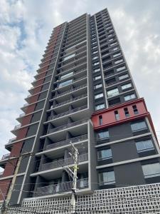 a tall apartment building with a red at 360 Suítes VN Turiassú by Housi - Apartamentos mobiliados in Sao Paulo