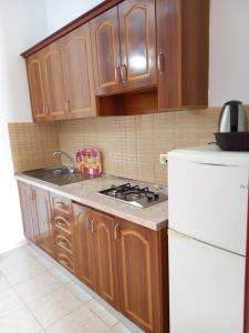 a kitchen with a stove and a white refrigerator at Apartments Kraja in Velipojë