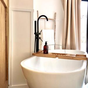 a bath tub in a bathroom with a sink at Luxury Barn with Hot Tub, Spa Treatments, Private Dining in Little Budworth