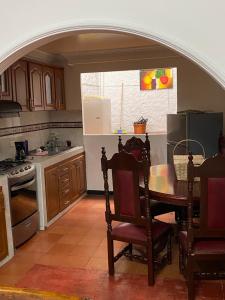 een keuken met een tafel met stoelen en een koelkast bij La Casona Hostal in Pereira