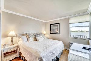 a white bedroom with a bed and a window at Cozy on Lover's Key in Fort Myers Beach +24 photos