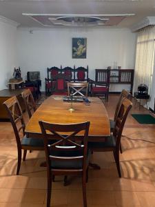 a dining room with a wooden table and chairs at La Casona Hostal in Pereira +28 photos
