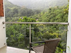 a chair on a balcony with a view of a mountain at Montes De Beraka in Minca