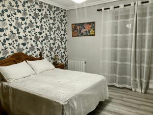 - une chambre avec un lit et un papier peint floral dans l'établissement CASA AYARAN, à Baeza