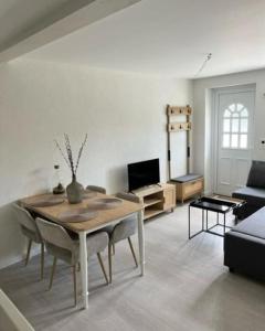 uma sala de estar com uma mesa e um sofá em Appartement douillet, aménagé proche riviera. em Attalens
