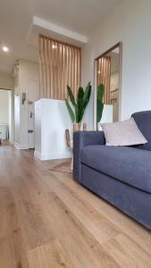 a living room with a blue couch and a mirror at Cristal 2 in Issoire