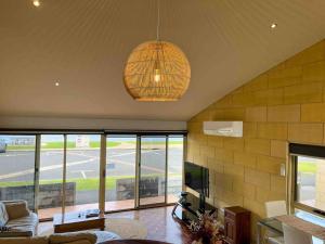 a living room with a chandelier hanging from the ceiling at Bayview no 2 in Port Campbell