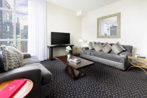 a living room with a couch and a tv at Millennium Hotel Broadway Times Square in New York