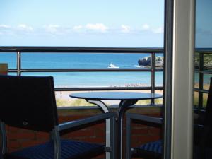 balcón con mesa y vistas a la playa en Apartamentos Maritimo Ris con garaje, en Noja