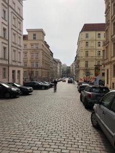 uma pessoa a andar de bicicleta numa rua com carros estacionados em TOP SPOT MITTE . THE PLACE TO BE ! em Berlim