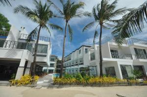 a group of palm trees in front of a building at Boracay Ocean Club Beach Resort in Boracay