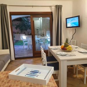 een woonkamer met een tafel en een eetkamer bij Insardinia House trilocale a 200mt dalla spiaggia in Olbia