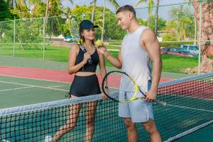 a man and a woman standing on a tennis court at Posada Real Puerto Escondido in Puerto Escondido