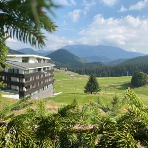 a view of a building with mountains in the background at Donovaly Triangel A10 in Mistríky