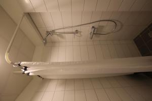 uma casa de banho com uma banheira e uma cabeça de chuveiro em 100 Iceland Hotel em Reykjavík