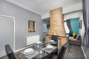 comedor con mesa, sillas y chimenea en Spacious town house free parking and Wi-Fi, en Thornaby on Tees