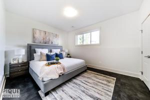 a bedroom with a bed with blue pillows and a window at Stunning Modern Suite - King Bed - Free Parking & Netflix - Fast Wi-Fi - Long Stays Welcome in Edmonton