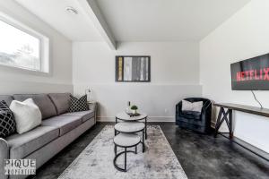 sala de estar con sofá y mesa en Stunning Modern Suite - King Bed - Free Parking & Netflix - Fast Wi-Fi - Long Stays Welcome, en Edmonton