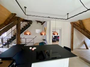 - une cuisine et un salon avec un comptoir noir et des escaliers dans l'établissement Design-Loft Appartement, à Berchtesgaden