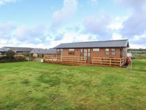 a log cabin in a field with a large yard at Ysgo Lodge in Pwllheli