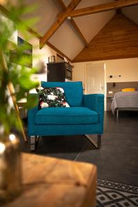 a blue couch in a living room with a bed at BenB Zuidoord in Zuidland