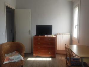 un soggiorno con TV su un comò in legno di 1er etage privatif dans une maison a La Colle-sur-Loup
