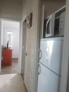 a white refrigerator in a room with a hallway at 1er etage privatif dans une maison in La Colle-sur-Loup