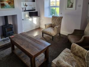 a living room with a table and chairs and a stove at Cranberry Cottage in South Creake
