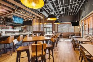 a restaurant with wooden tables and chairs and a bar at Best Western Plus Merritt Hotel in Merritt