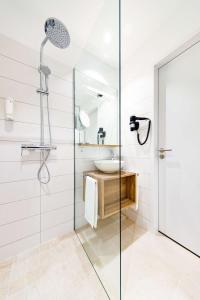 a bathroom with a glass shower and a sink at elaya hotel goeppingen, Trademark Collection by Wyndham in Göppingen